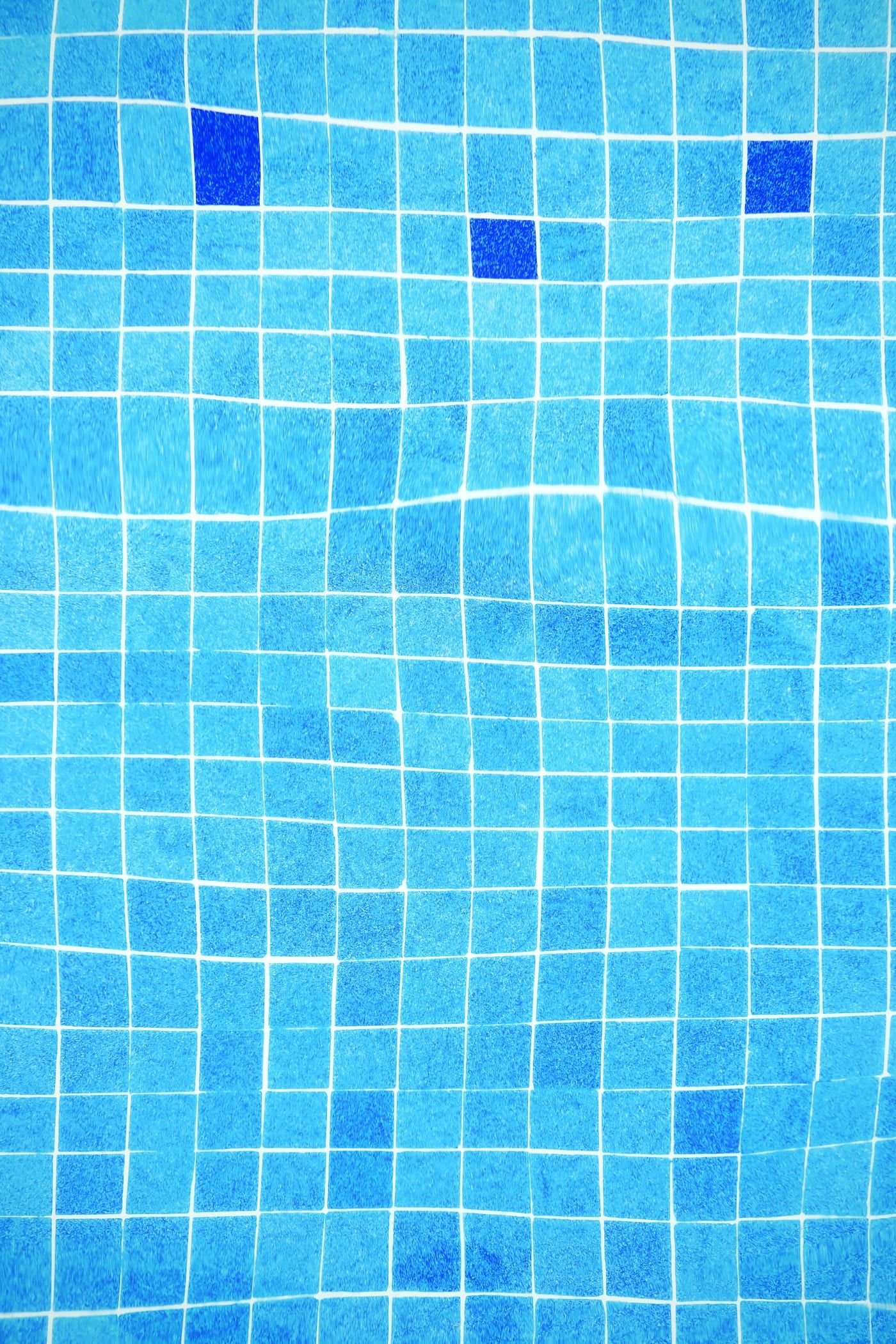 Azulejo azul de piscina visto através da água limpa